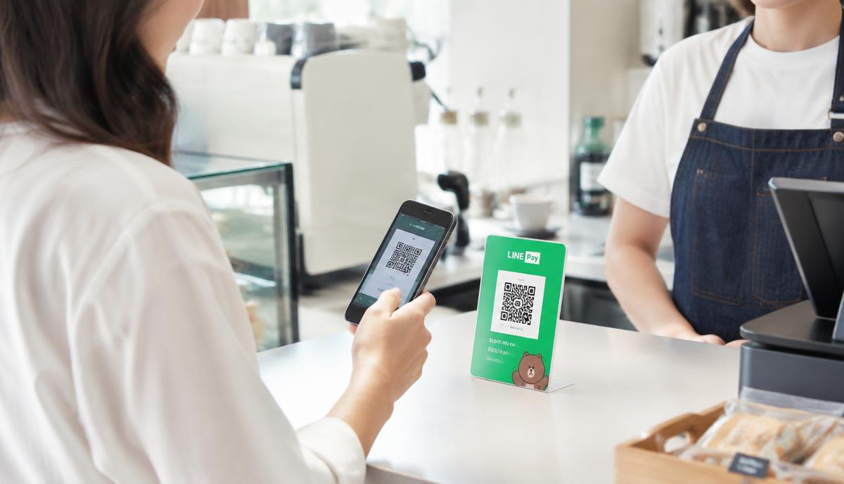 Customer scanning a QR code stand on a cafe counter with a phone